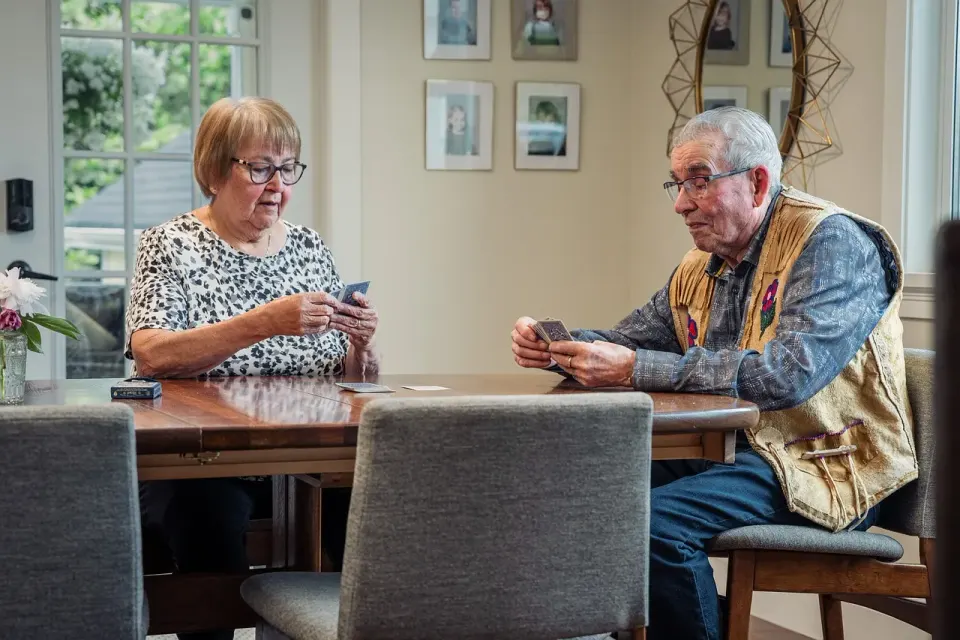 An older couple playing a card game together at a table