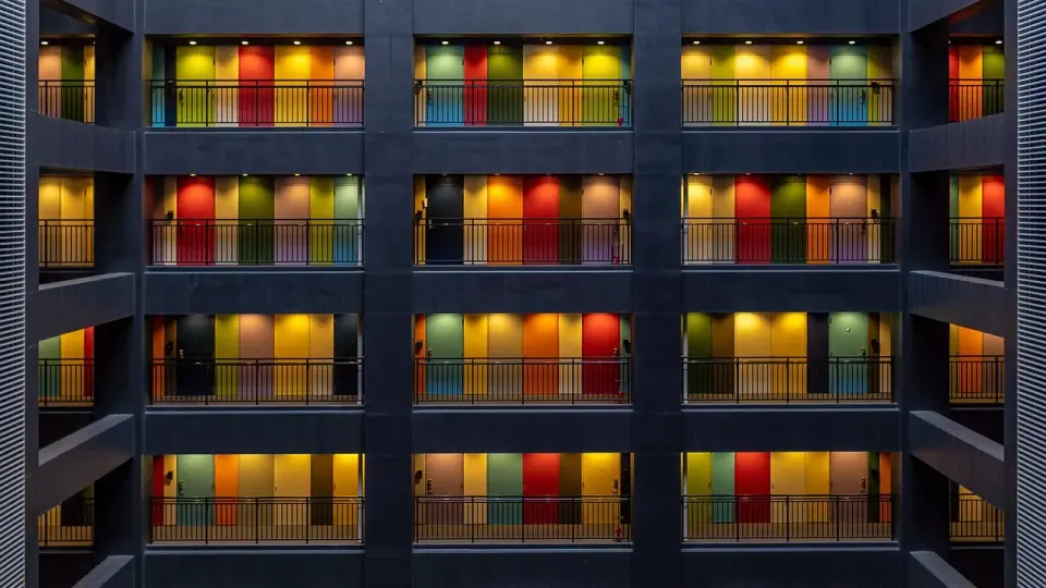 Apartment building with rows of colorful doors along open balconies