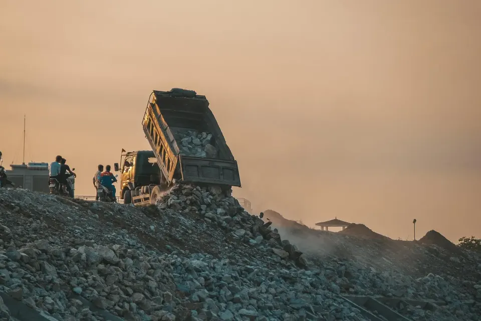 Dump truck unloading household waste at a landfill