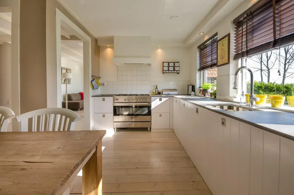 Bright updated kitchen with white cabinets and light wood floors