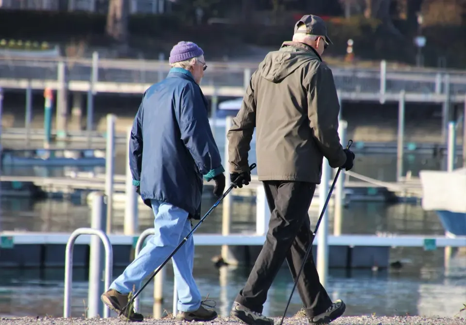 An older couple walking together along a park path