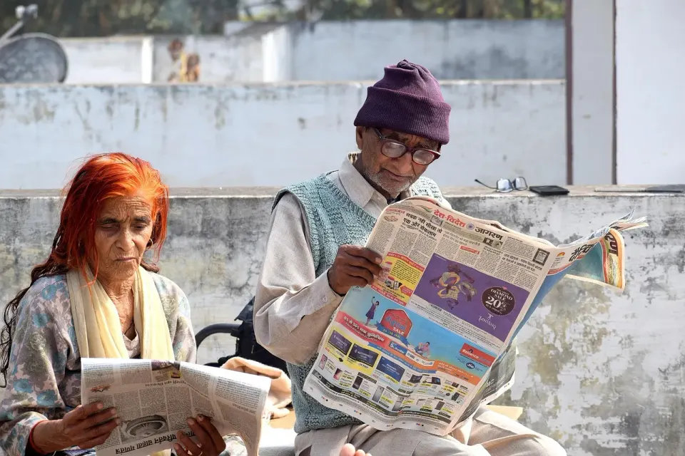 An older couple sitting together and reading at home
